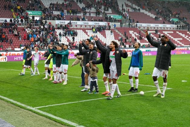 Schlussjubel bei den Fans, die Spieler feiern ihren Sieg, FC Augsburg vs. VfL Wolfsburg, Fussball, 1. Bundesliga, 6. Spieltag, 04.10.2025 DFB regulations prohibit any use of photographs as image sequences and or quasi-video Augsburg Bayern Deutschland