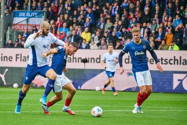 04.10.2025, Fußball, Herren, 2.BL (Bundesliga), Saison 2025 2026, Holstein Kiel - SV Darmstadt 98, 8. Spieltag Adrian Kapralik gegen Aleksandar Vukotic, daneben Phil Harres Kiel, Holstein-Stadion Holstein-Stadion Schleswig-Holstein Deutschland