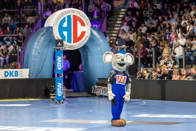 Das Maskottchen Maus in der hell erleuchteten Halle im Hintergrund das Logo des HC Erlangen. HC Erlangen vs. Fuechse Berlin, Handball, 1. Handball Bundesliga, Saison 2025 2026, 7. Spieltag, 04.10.2025 HC Erlangen vs. Fuechse Berlin, Handball, 1. Handball Bundesliga, Saison 2025 2026, 7. Spieltag, 04.10.2025 Nuernberg Copyright: xEibner-Pressefoto ArdanxFuessmanx EP_AFN