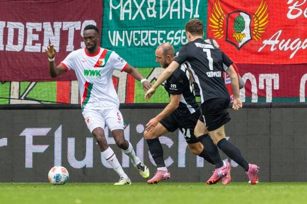 Chrislain Matsima (FC Augsburg), Christian Eriksen 24 (VfL Wolfsburg) und Andreas Skov Olsen 7 (VfL Wolfsburg) v-l im Zweikampf, FC Augsburg vs. VfL Wolfsburg, Fussball, 1. Bundesliga, 6. Spieltag, 04.10.2025 DFB regulations prohibit any use of photographs as image sequences and or quasi-video Augsburg Bayern Deutschland