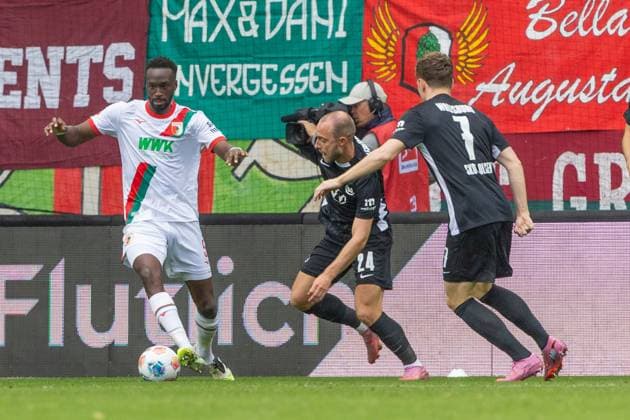 Chrislain Matsima (FC Augsburg), Christian Eriksen 24 (VfL Wolfsburg) und Andreas Skov Olsen 7 (VfL Wolfsburg) v-l im Zweikampf, FC Augsburg vs. VfL Wolfsburg, Fussball, 1. Bundesliga, 6. Spieltag, 04.10.2025 DFB regulations prohibit any use of photographs as image sequences and or quasi-video Augsburg Bayern Deutschland