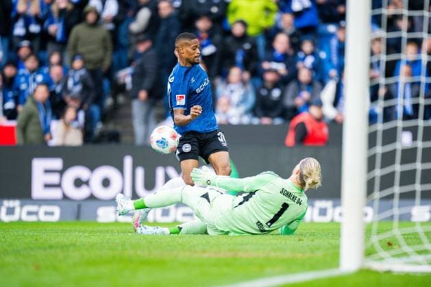 05.10.2025 - Fußball, 2025 2026, 2. Bundesliga, 8. Spieltag, DSC Arminia Bielefeld - FC Schalke 04: (L-R) Isaiah Young (Bielefeld), Loris Karius (Schalke) DFL REGULATIONS PROHIBIT ANY USE OF PHOTOGRAPHS AS IMAGE SEQUENCES AND OR QUASI-VIDEO.