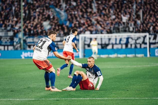 Fußball Männer Saison 2025 2026 1. Fußball-Bundesliga 6. Spieltag Hamburger SV vs. 1. FSV Mainz 05 05.10.2025 v.l. Nicolai Remberg ( 21, HSV) hilft Miro Muheim ( 28, HSV) vom Boden auf Hamburg Volksparkstadion Hamburg Deutschland