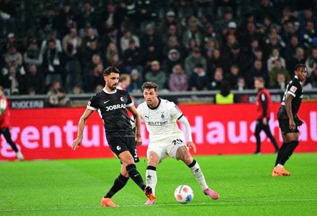 05.10.2025; Moenchengladbach; Fussball, Herren, Saison 2025 2026, Borussia Moenchengladbach vs. SC Freiburg Vincenzo Grifo (Freiburg, li.) klaert vor Joe Scally (Gladbach, re.) DFL regulations prohibit any use of photographs as image sequences and or quasi-video. Borussia-Park NRW Deutschland
