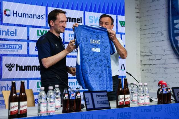 Geschäftsführer Otmar Schork (1. FC Magdeburg) überreicht dem Leiter Medien und Kommunikation Pressesprecher Manuel Holscher (1. FC Magdeburg) ein unterschriebenes Trikot der Mannschaft mit der Aufschrift, Danke Manu. Der Pressesprecher verlässt den Verein auf eigenem Wunsch - 2. Fußball Bundesliga Saison 2025-2026 Pressekonferenz mit dem Geschäftsführer Sport Otmar Schork (1. FC Magdeburg) vom 1. FC Magdeburg in der Avnet Arena in Magdeburg - Fußball,Mann,Männer,Deutschland,07.10.2025