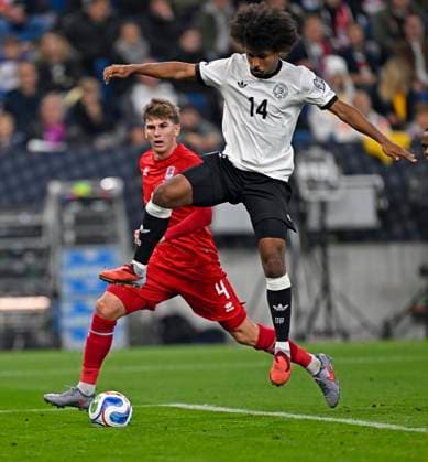10.10.2025, Fussball WM-Qualifikation Europa 2025 26, 7.Spieltag, Deutschland - Luxemburg, in der PreZero-Arena (Sinsheim). v.l. Florian Bohnert (Luxemburg) gegen Karim Adeyemi (Deutschland)