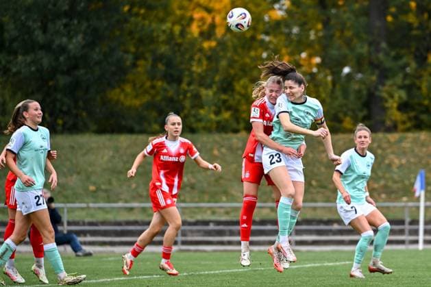 12.10.2025, Fußball, 2. Frauen-Bundesliga, 2025 2026, 7. Spieltag, SG 99 Andernach - FC Bayern München II Marie Gmeineder (6 Bayern München II) hält während des Kopfballs Magdalena Schumacher (23 Andernach) fest.