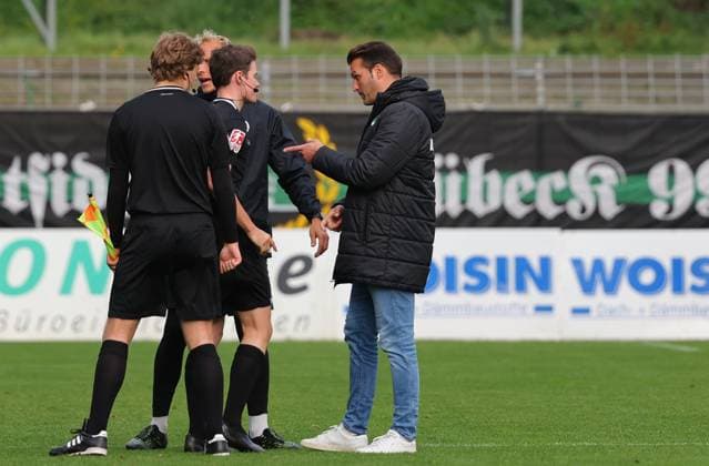 GER, Regionalliga Nord, VfB Luebeck vs HSC Hannover 12.10.2025, Dietmar-Scholze-Stadion an der Lohmuehle, Luebeck, GER, Regionalliga Nord, VfB Luebeck vs HSC Hannover im Bild picture shows Spielende. Endstand 1:2. Schiedsrichter Lennart Wolff mit Trainer Guerino Capretti (VfB Luebeck)