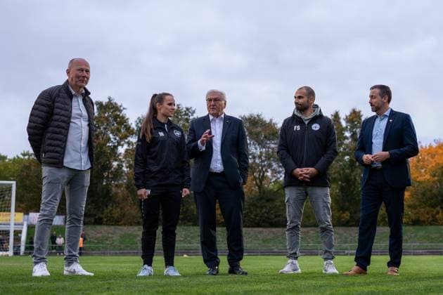 14.10.2025, GER, Besuch des Bundespräsidenten bei einem Training der Fußballerinnen der SG 99 Andernach v. l. n. r.: Teammanager Bodo Heinemann, Trainerin Isabelle Hawel, Bundespräsident Frank-Walter Steinmeier, Geschäftsführer Florian Stein und Oberbürgermeister Christian Greiner im Gespräch auf dem Trainingsplatz.