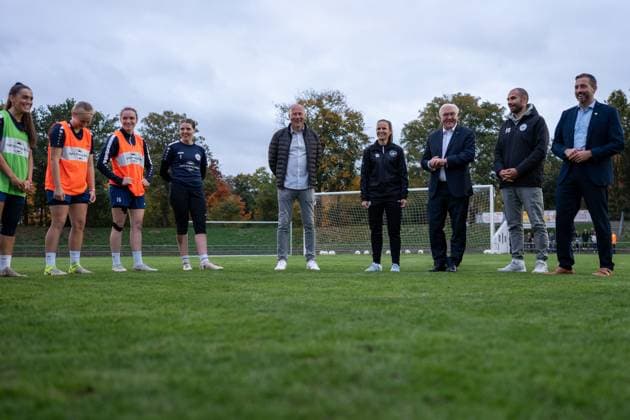 RECORD DATE NOT STATED 14.10.2025, GER, Besuch des Bundespräsidenten bei einem Training der Fußballerinnen der SG 99 Andernach Nach Ankunft des Bundespräsidenten Frank-Walter Steinmeier unterbrechen die Spielerinnen ihr Training und heißen ihn willkommen. Die Spielerinnen und das Staff-Team stehen in einem Kreis zusammen.