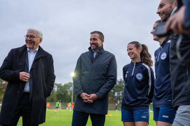 14.10.2025, GER, Besuch des Bundespräsidenten bei einem Training der Fußballerinnen der SG 99 Andernach Bundespräsident Frank-Walter Steinmeier, Oberbürgermeister Christian Greiner, die Kapitäninnen Lisa Kossmann und Magdalena Schumacher sowie Geschäftsführer Florian Stein führen am Rande des Platzes Gespräche.