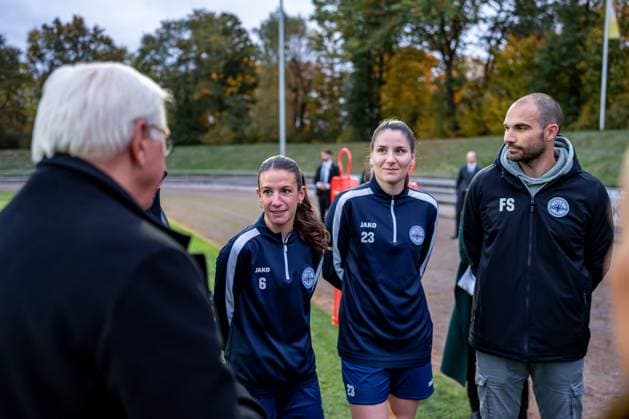 14.10.2025, GER, Besuch des Bundespräsidenten bei einem Training der Fußballerinnen der SG 99 Andernach Die Kapitäninnen Lisa Kossmann (6) und Magdalena Schumacher (23) sowie Geschäftsführer Florian Stein im Austausch mit Bundespräsident Frank-Walter Steinmeier.
