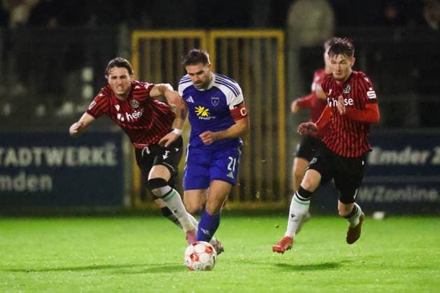 15.10.2025, Fussball, Herren, Regionalliga Nord, 8. Spieltag, BSV Kickers Emden - Hannover 96 II Tido Steffens (blau 21 BSV Kickers Emden) im Zweikampf mit Ilias Ebnoutalib (links 4 Hannover 96 II) und Keanu Brandt (10 Hannover 96 II)