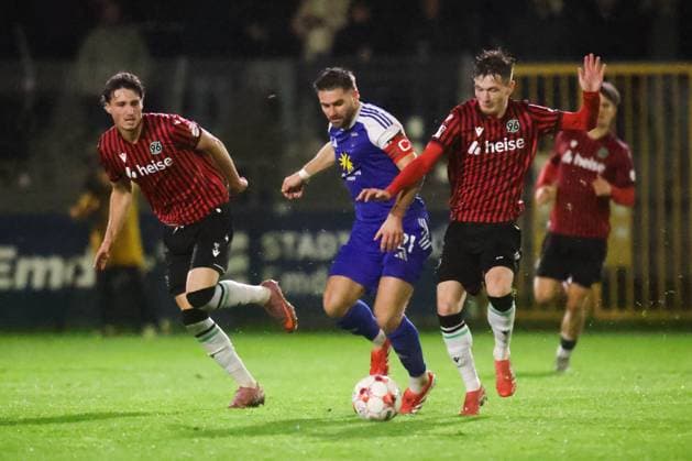 15.10.2025, Fussball, Herren, Regionalliga Nord, 8. Spieltag, BSV Kickers Emden - Hannover 96 II Tido Steffens (blau 21 BSV Kickers Emden) im Zweikampf mit Ilias Ebnoutalib (links 4 Hannover 96 II) und Keanu Brandt (10 Hannover 96 II)
