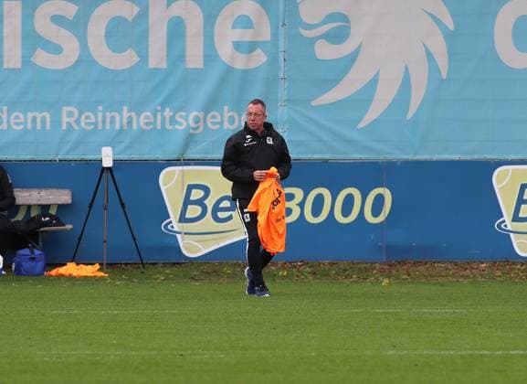 Fussball, Herren, 3.Liga, Saison 2025 2026, TSV 1860 München, Training Markus Kauczinski, Trainer (TSV 1860 München) mit Leibchen zum Verteilen in der Hand