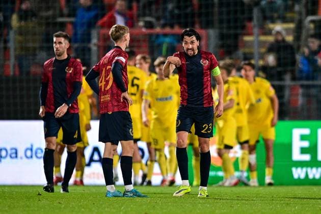Unterhachinger Spieler nach dem Gegentor zum 0:1 enttäuscht schauend, Enttäuschung, Frustration, disappointed, pessimistisch, im Hintergund bejubeln dis Bayreuther Spieler das Tor, 17.10.2025, Unterhaching (Deutschland), Fussball, Regionalliga Bayern, SpVgg Unterhaching - SpVgg Bayreuth