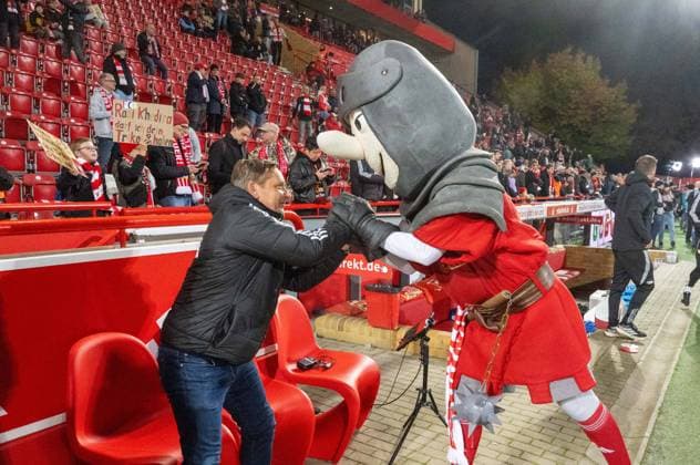 Fußball, Herren, Saison 2025 2026, 1. Bundesliga (7. Spieltag), 1. FC Union Berlin - Borussia Mönchengladbach, v. l. Profifußball-Geschäftsführer Horst Heldt (1. FC Union Berlin), Maskottchen Ritter Keule (1. FC Union), 17.10.2025, Copyright: xMatthiasxKochx