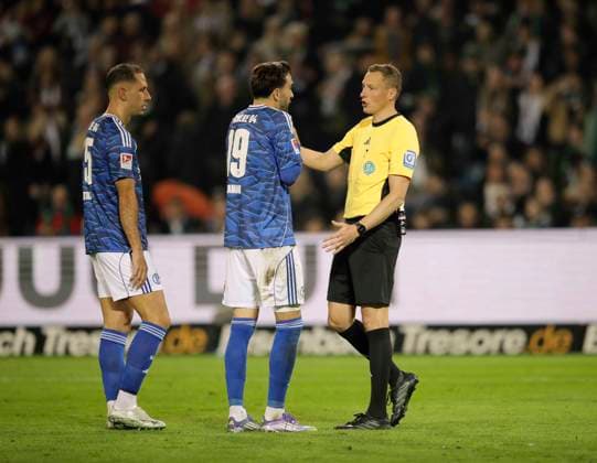 Foto : Schiri Martin Petersen streitet mit Kenan Karaman (Schalke) nach dem Pfiff zum 3. Elfmeter für Hannover Fussball 2. Liga , 9. Spieltag am Fr. 17.10.2025 Hannover 96 - Schalke 04