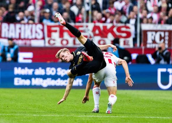 Köln, RheinEnergieStadion, 18.10.2025: Anton Kade of Augsburg challenges Marius Buelter of Koeln during the 1.Bundesliga match 1.FC Köln vs. FC Augsburg.