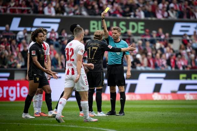 1. FC Koeln vs. FC Augsburg, 18.10.2025 KOELN, GERMANY - OCTOBER 18: Referee Timo Gerach (Landau) shows Kristijan Jakic (FC Augsburg, 17) the yellow card during the Bundesliga match between 1. FC Koeln vs. FC Augsburg at the Rheinenergie-Stadion on matchday 7 of the 1. Bundesliga on October 18, 2025 in Koeln, Germany. DFL REGULATIONS PROHIBIT ANY USE OF PHOTOGRAPHS AS IMAGE SEQUENCES AND OR QUASI-VIDEO. Copyright: xBEAUTIFULxSPORTS AxelxKohringx