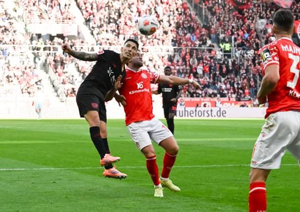 18.10.2025, xsltx, Fussball 1.Bundesliga, FSV Mainz 05 - Bayer 04 Leverkusen v.l. Alejandro Grimaldo (Bayer 04 Leverkusen) und Benedict Hollerbach (1. FSV Mainz 05) im Kopfballduell (DFL DFB REGULATIONS PROHIBIT ANY USE OF PHOTOGRAPHS as IMAGE SEQUENCES and or QUASI-VIDEO)