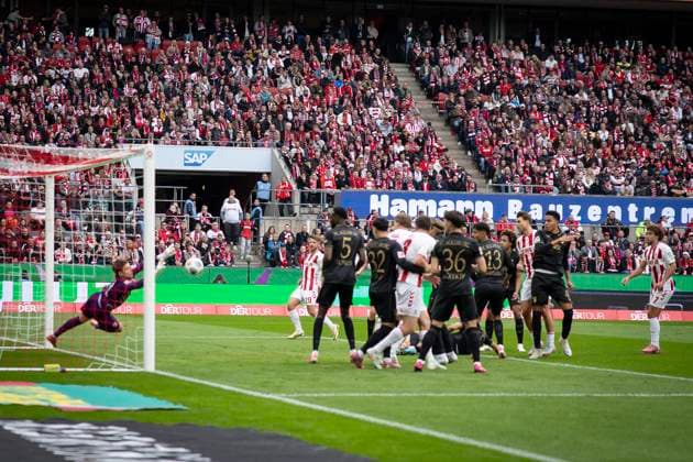 KOELN, GERMANY - OCTOBER 18: Keeper Finn Dahmen (FC Augsburg, 1) seven the ball after a corner during the Bundesliga match between 1. FC Koeln vs. FC Augsburg at the Rheinenergie-Stadion on matchday 7 of the 1. Bundesliga on October 18, 2025 in Koeln, Germany. DFL REGULATIONS PROHIBIT ANY USE OF PHOTOGRAPHS AS IMAGE SEQUENCES AND OR QUASI-VIDEO. Nordrhein-Westfalen Germany Copyright: xBEAUTIFULxSPORTS AxelxKohringx