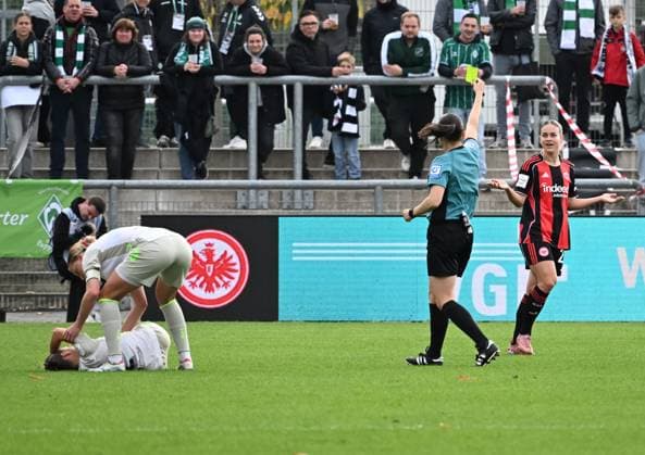 19.10.2025, xsltx, Fussball Google Pixel Frauen-Bundesliga, Eintracht Frankfurt - Werder Bremen v.l. Die gefoulte Chiara D Angelo (Werder Bremen) am Bode, re. Zeigt Angelika Söder (Schiedsrichterin) Nadine Riesen (Eintracht Frankfurt) die gelbe Karte (DFL DFB REGULATIONS PROHIBIT ANY USE OF PHOTOGRAPHS as IMAGE SEQUENCES and or QUASI-VIDEO)