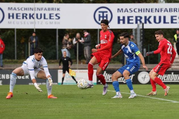 Männer Fußball Fussball Regionalliga Nord-Ost Saison 2025 26 10. Spieltag 19.10.2025 Bluechip Arena Meuselwitz Thüringen ZFC Meuselwitz - 1. FC Magdeburg II Elias Ndukwe ZFC rot wird vom Robert Kampa im Magdeburger Torhüter von den Beinen geholt ohne Konsequenz - Mihailo Trkulja Magdeburg schaut zu Meuselwitz Thueringen Germany