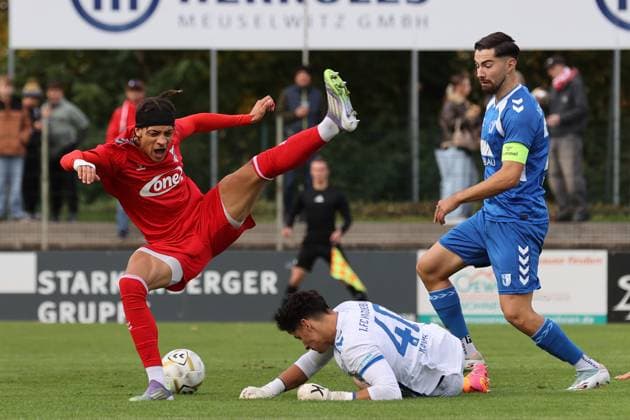 Männer Fußball Fussball Regionalliga Nord-Ost Saison 2025 26 10. Spieltag 19.10.2025 Bluechip Arena Meuselwitz Thüringen ZFC Meuselwitz - 1. FC Magdeburg II Elias Ndukwe ZFC rot wird vom Robert Kampa im Magdeburger Torhüter von den Beinen geholt ohne Konsequenz - Mihailo Trkulja Magdeburg schaut zu Meuselwitz Thueringen Germany