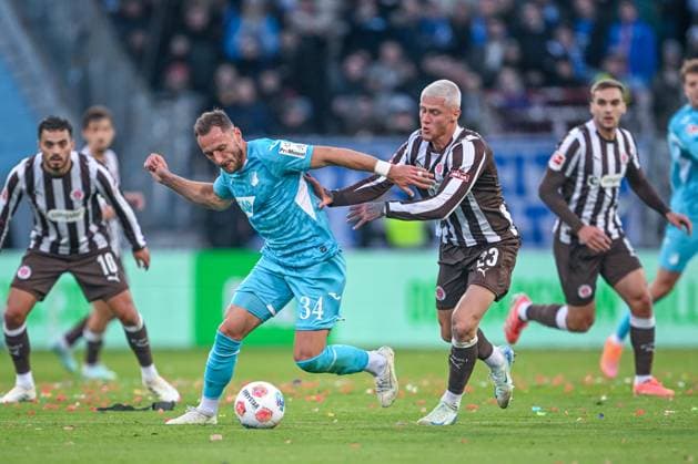 Fußball - 1. Bundesliga - FC St. Pauli - TSG Hoffenheim am 19.10.2025 im Millerntor-Stadion in Hamburg David Mokwa (Hoffenheim) im Zweikampf gegen Louis Oppie (St. Pauli)