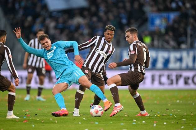 Fußball - 1. Bundesliga - FC St. Pauli - TSG Hoffenheim am 19.10.2025 im Millerntor-Stadion in Hamburg Fisnik Asllani (Hoffenheim) im Zweikampf gegen Joel Chima Fujita (St. Pauli) und James Sands (St. Pauli)