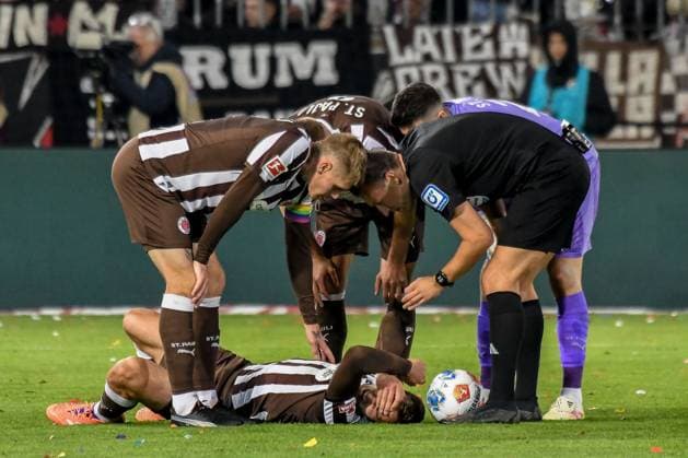 James Sands ( Pauli ) liegt am Boden Eric Smith( Pauli ) Schiedsrichter Sven Jablonski bei ihm Deutschland , Hamburg , Millerntorstadion , Fussball , 1. Bundesliga , FC St Pauli - TSG Hoffenheim