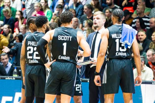 22.10.2025, xomx, Basketball BKT EuroCup, NINERS Chemnitz - London Lions v.l. Spielerkreis, Mannschaftskreis, Abklatschen. Tarik Phillip (London Lions), Joel Scott (London Lions), Tautvydas Sabonis (London Lions), Jonathan Williams (London Lions) Chemnitz