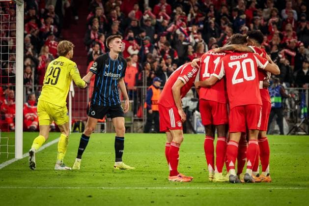 Jorne Spileers 58 (Club Brugge), Mitte, hilft dem geschlagenen Nordin Jackers 29 (Club Brugge) auf, waehrend die Mannschaft (FC Bayern Muenchen) ueber das 4:0 von Nicolas Jackson 11 (FC Bayern Muenchen) jubelt, FC Bayern Muenchen vs. Club Brugge, Fussball, Maenner, UEFA Champions League, Saison 2025 2026, Allianz Arena, 3. Spieltag, 22.10.2025 Muenchen Bayern Deutschland