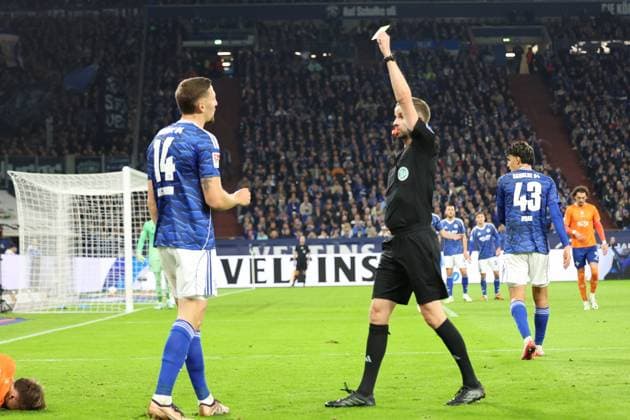 24.10.2025, xrekx, Fussball 2.Bundesliga, FC Schalke 04 - SV Darmstadt 98 v.l. Schiedsrichter Referee Michael Bacher zeigt Janik Bachmann (FC Schalke 04) die Gelbe Karte (DFL DFB REGULATIONS PROHIBIT ANY USE OF PHOTOGRAPHS as IMAGE SEQUENCES and or QUASI-VIDEO) Gelsenkirchen