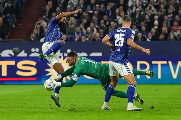 Gelsenkirchen, Deutschland, 24.10.25: Moussa Sylla (FC Schalke 04), Torwart Marcel Schuhen (SV Darmstadt 98) und Nikola Katic (FC Schalke 04) im Kampf um den Ball während des Spiels der 2. Bundesliga zwischen FC Schalke 04 - SV Darmstadt 98 in der Veltins-Arena am 24. October 2025 in Gelsenkirchen, Deutschland. Gelsenkirchen Veltins-Arena Germany