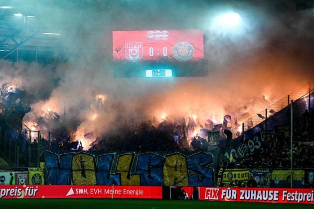 Fußball I Herren I Saison 2025-2026 I Regionalliga I 13. Spieltag I Hallescher FC - 1. FC Lokomotive Leipzig I 24.10.2025 Leipziger Fans im Gästeblock zünden zum Anpfiff Pyrothechnik Halle (Saale) Leuna-Chemie-Stadion Sachsen-Anhalt Deutschland Copyright: xLobeca InesxHähnelx