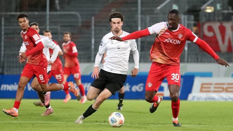 24.10.2025, xfsx, Herren, Fussball, Saison 2025 2026, Regionalliga Bayern, 15. Spieltag: SV Wacker Bughausen - FC Wuerzburger Kickers v.li.: Jermain Nischalke (FC Wuerzburger Kickers), Moritz Bangerter (SV Wacker Burghausen), Tarsis Bonga (FC Wuerzburger Kickers) Burghausen Wacker-Arena Bayern Deutschland