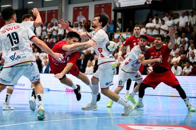 Huettenberg: HBL - 25 26 - TV Huettenberg - SG BBM Bietigheim Juan de la Pena (Bietigheim) mit dem PAss auf Jonathan Fischer (Bietigheim), dazwischen Hendrik Schreiber (Huettenberg) Huettenberg Sportzentrum Deutschland