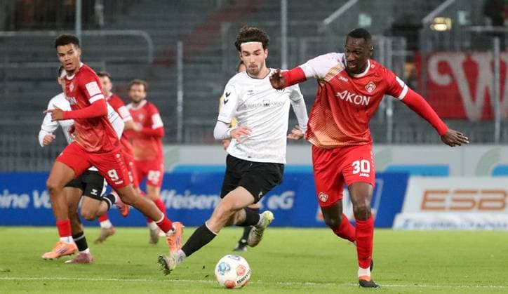 24.10.2025, xfsx, Herren, Fussball, Saison 2025 2026, Regionalliga Bayern, 15. Spieltag: SV Wacker Bughausen - FC Wuerzburger Kickers v.li.: Jermain Nischalke (FC Wuerzburger Kickers), Moritz Bangerter (SV Wacker Burghausen), Tarsis Bonga (FC Wuerzburger Kickers) Burghausen Wacker-Arena Bayern Deutschland