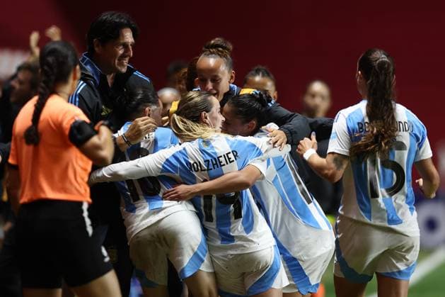 Argentina s midfielder Maricel Pereyra (hidden-C) celebrates with head coach German Portanova (L) and teammates after scoring the team™s third goal during the CONMEBOL Women s Nations League football match, qualifier for the 2027 World Cup in Brazil, between Argentina and Paraguay, at the Diego Armando Maradona stadium in Buenos Aires, Argentina on October 24, 2025. BUENOS AIRES ARGENTINA Copyright: xALEJANDROxPAGNIx