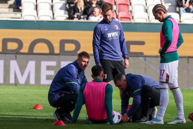 Schreckmoment beim warm-up: Dimitris Giannoulis 13 (FC Augsburg) muss behandelt werden, kann aber weitermachen, FC Augsburg vs. RB Leipzig, Fussball, Maenner, DFL, Bundesliga, Saison 2025 2026, WWK Arena, 8. Spieltag, 25.10.2025 Augsburg Bayern Deutschland
