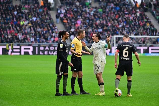 25.10.2025; Moenchengladbach; Fussball, Herren, Saison 2025 2026, Borussia Moenchengladbach vs. Bayern Muenchen Viel Gespraechsbedarf mit Schiedsrichter Sascha Stegemann. v. li. Michael Olise (Bayern), Schiedsrichter Sascha Stegemann, Rocco Reitz (Gladbach), Joshua Kimmich (Bayern) DFL regulations prohibit any use of photographs as image sequences and or quasi-video. Borussia-Park NRW Deutschland
