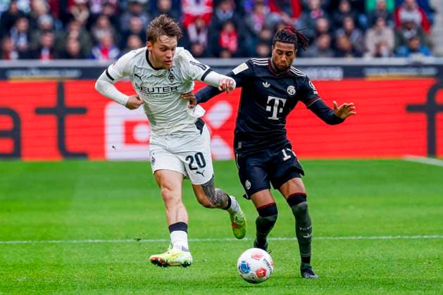 Luca Netz of Borussia Mönchengladbach passes the ball under pressure from Michael Olise of FC Bayern München Borussia Mönchengladbach v FC Bayern München, Bundesliga, Borussia Mönchengladbach v FC Bayern München, Stadion im Borussia-Park, October 25, 2025, Mönchengladbach, Germany.