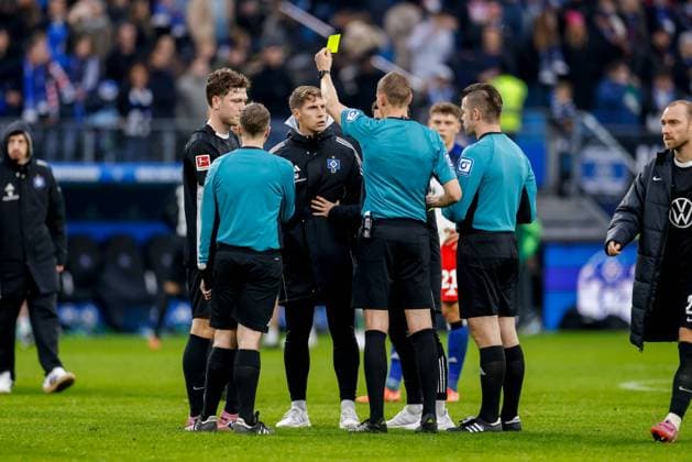 Hamburg, 25. Oktober 2025 - Fußball, 1. Bundesliga 2025 26, Hamburger SV - VfL Wolfsburg: Schiedsrichter Martin Petersen zeigt Loic Fave (Hamburger SV, Co-Trainer) nach Abpfiff die gelbe Karte DFL REGULATIONS PROHIBIT ANY USE OF PHOTOGRAPHS AS IMAGE SEQUENCES AND OR QUASI-VIDEO.