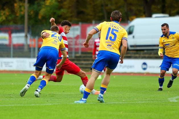 Bild: v.li.: Moritz Fritz 23(FC Carl Zeiss Jena) vs. Soufian Benyamina 90(Greifswalder FC) und Marcel Hoppe 15(FC Carl Zeiss Jena) --- Regionalliga Nordost Greifswalder FC (rot) gegen FC Carl Zeiss Jena (gelb) 25.10.2025 in Greifswald