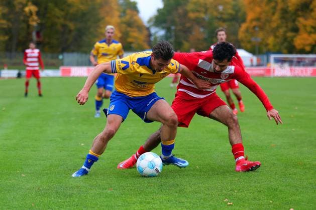 Bild: v.li.: Marcel Hoppe 15(FC Carl Zeiss Jena) vs. Osman Atilgan 99(Greifswalder FC) --- Regionalliga Nordost Greifswalder FC (rot) gegen FC Carl Zeiss Jena (gelb) 25.10.2025 in Greifswald