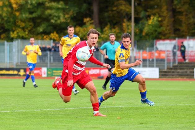 Bild: v.li.: Theo Harz 33(Greifswalder FC) vs. Marcel Hoppe 15(FC Carl Zeiss Jena) --- Regionalliga Nordost Greifswalder FC (rot) gegen FC Carl Zeiss Jena (gelb) 25.10.2025 in Greifswald