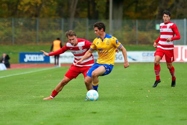 Bild: v.li.: Theo Harz 33(Greifswalder FC) vs. Marcel Hoppe 15(FC Carl Zeiss Jena) --- Regionalliga Nordost Greifswalder FC (rot) gegen FC Carl Zeiss Jena (gelb) 25.10.2025 in Greifswald