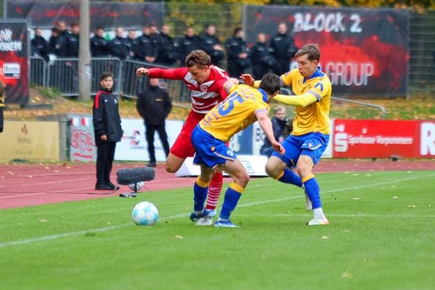 Bild: v.li.: Joe-Joe Richardson 10(Greifswalder FC) vs. Marcel Hoppe 15(FC Carl Zeiss Jena) --- Regionalliga Nordost Greifswalder FC (rot) gegen FC Carl Zeiss Jena (gelb) 25.10.2025 in Greifswald
